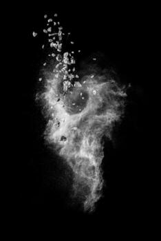 Split debris of stone exploding with white dust against black background. photo