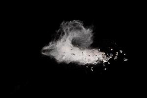 Split debris of stone exploding with white dust against black background. photo