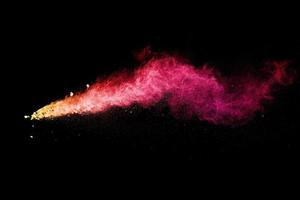 Split debris of stone exploding with red dust against black background. photo