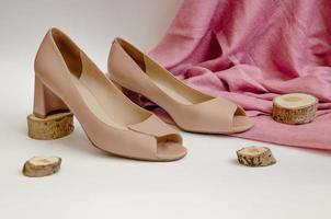 beige high heel shoes on a light background with a pink scarf photo