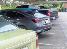 borroso foto, desenfocado imagen, recoger camión y carros estacionamiento ordenado a Departamento Tienda estacionamiento lote, abierto zona estacionamiento lote con techo, coche posterior lado foto