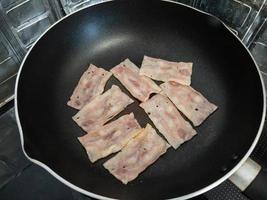 The smoked bacon grilled on the non-stick pan. photo