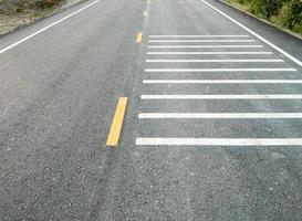 The white transverse rumble strips on the asphalt road. photo