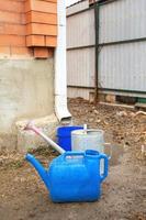 colección de agua de lluvia en diferente botes cubos, riego latas en el yarda de su casa cerca el bajante para más lejos utilizar y riego, espacio para texto foto
