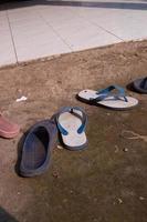 worn sandals scattered on the ground photo