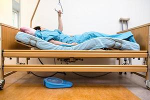 curved hospital bed with patient holding handle photo