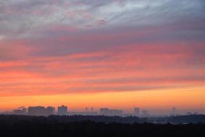 layered colorful sky over city park at cold dawn photo