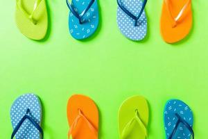 a lot of flip flop colored sandals, summer vacation on colored background, copy space top view photo