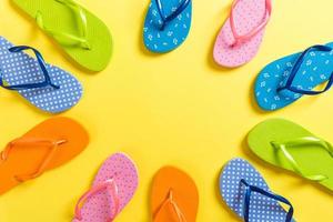 a lot of flip flop colored sandals, summer vacation on colored background, copy space top view