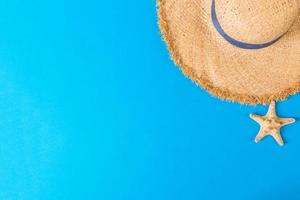 yellow retro straw hat with seastar top view with copy space. summer concept on blue background photo