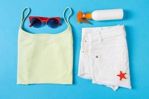 Flat lay composition with Beach accessories on blue color background. Summer holiday background. Vacation and travel items top view photo