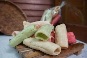 selective focus on colorful crackers on a tray wood, in Indonesian it is called kerupuk pelompong or krupuk pipa, soft focus photo