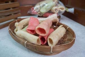 selective focus on colorful crackers on a bamboo plate, in Indonesian it is called kerupuk pelompong or krupuk pipa , soft focus photo