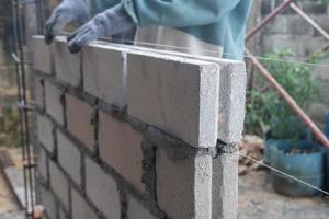 selective focus on bricks being installed by builders, concept photo of the process of building a house, warehouse. soft focus