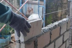 selective focus on bricks being installed by builders, concept photo of the process of building a house, warehouse. soft focus