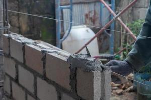 selective focus on bricks being installed by builders, concept photo of the process of building a house, warehouse. soft focus