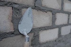 selectively focus on the dirty cement spoon because it is used to install bricks, in Indonesian the cement spoon is called cetok, soft focus photo