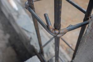 selective focus on wire tying round iron bar to building poles at construction site, soft focus photo