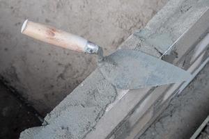 selectively focus on the dirty cement spoon because it is used to install bricks, in Indonesian the cement spoon is called cetok, soft focus photo