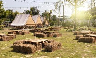 Straw seats and pallet wood table and outdoor living tent on lawn photo