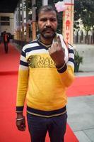 New Delhi, India - December 04 2022 - Unidentified people showing their ink-marked fingers after casting votes in front of polling booth of east Delhi area for MCD local body Elections 2022 photo