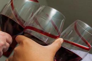 Cheering Glasses with Red Wine photo