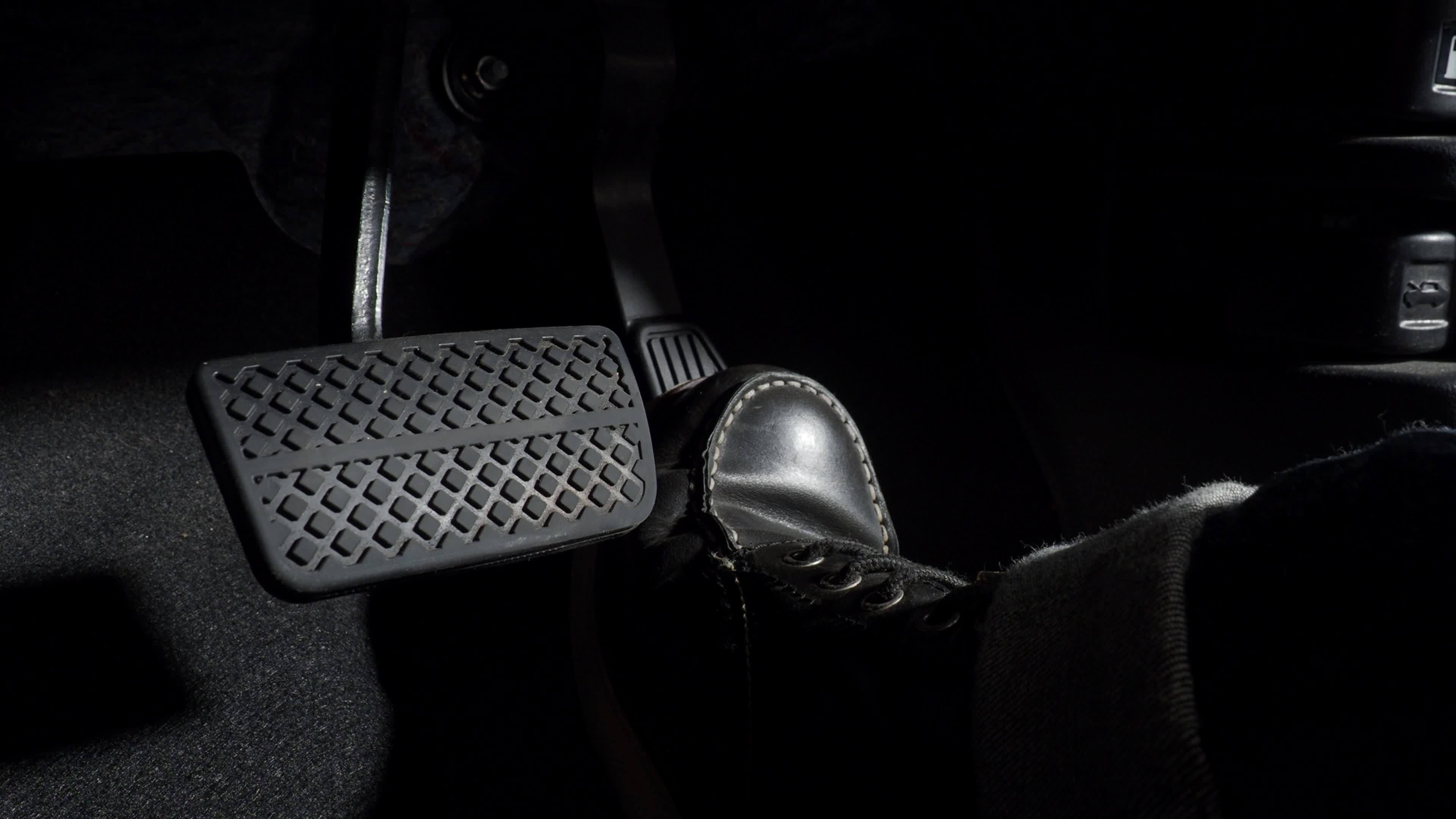 Accelerate and Brake. Foot pressing foot pedal of a car to drive ahead