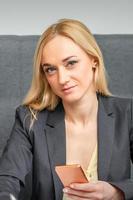 Businesswoman with smartphone working in office photo