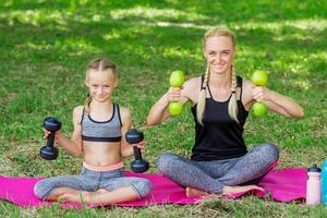 Young woman and girl are training with dumbbells photo