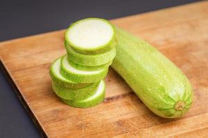 Slices of courgettes on wooden board photo