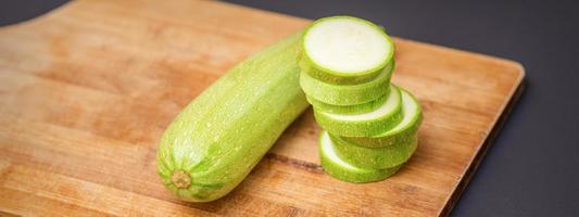 Slices of courgettes on wooden board photo