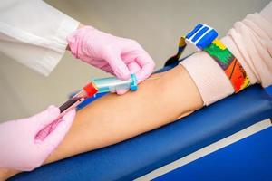 Nurse takes blood sample from vein photo