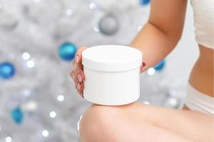 White plastic jar in hand of woman photo