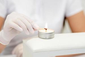 Manicure master is lighting candle photo