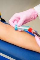 Nurse takes blood sample from vein photo