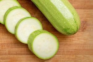 Slices of courgettes on wooden board photo