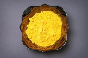 Turmeric powder in ceramic black bowl photo