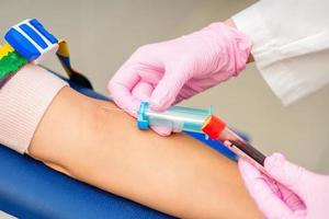 Nurse takes blood sample from vein photo