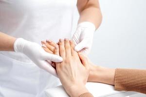 Manicurist massaging female hand with manicure photo