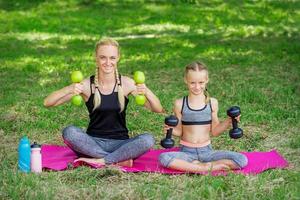 Young woman and girl are training with dumbbells photo