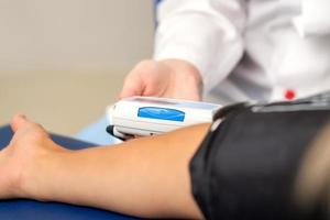Nurse measuring arterial blood pressure photo