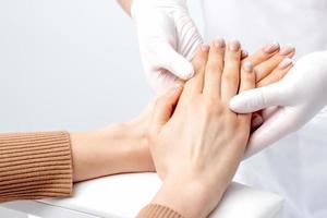 Manicurist massaging female hand with manicure photo