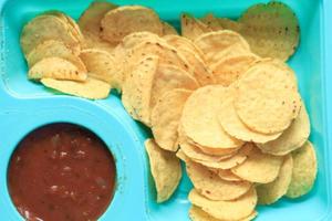 un tazón de papas fritas y salsa en la mesa, foto