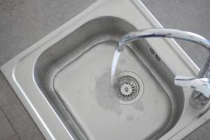 top view of faucet with flowing water photo