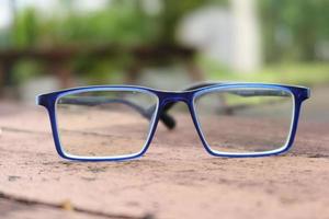 anteojos de color azul y teléfono inteligente en la mesa foto