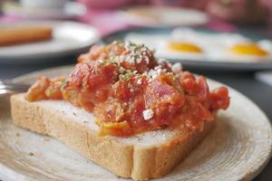 morning breakfast with Scrambled eggs on a bread on white plate photo