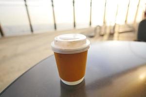 take away paper coffee cup o on cafe table photo
