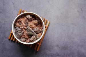 Himalayan black salt rock crystals, Kala Namak in a container on table photo