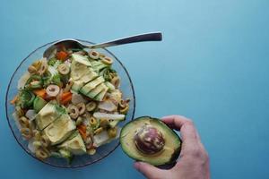 young women eating avocado salad photo