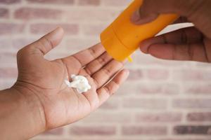 pov shot of young men using sunscreen cream photo